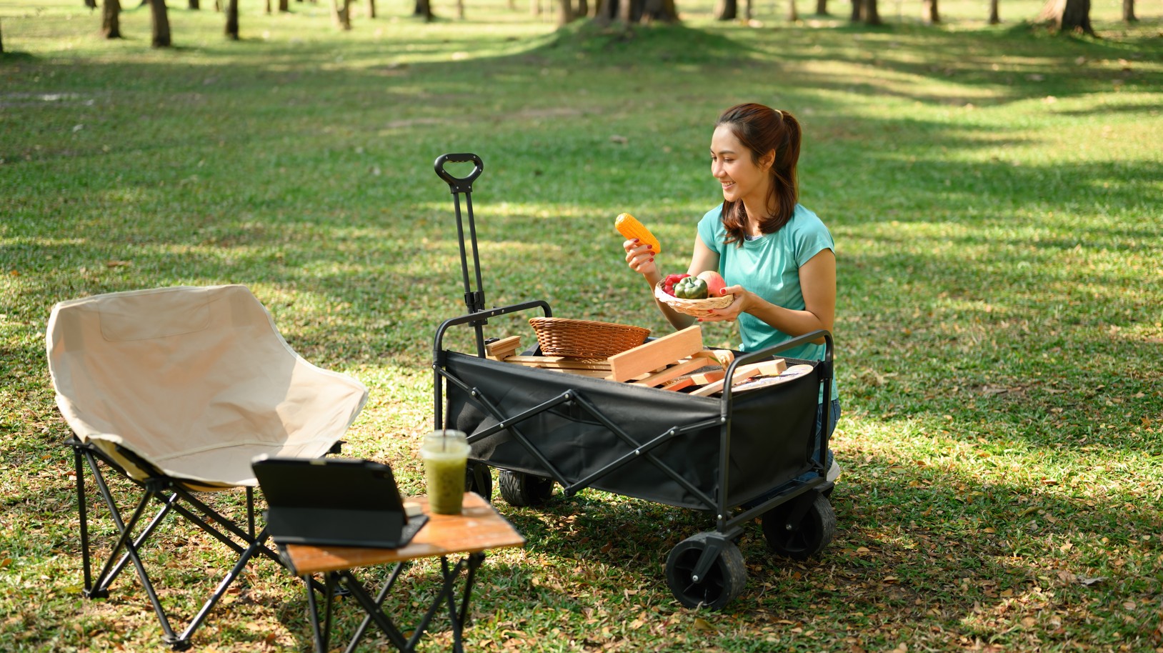 Roter Bollerwagen mit Holzaufbau steht auf einem Feldweg im Grünen